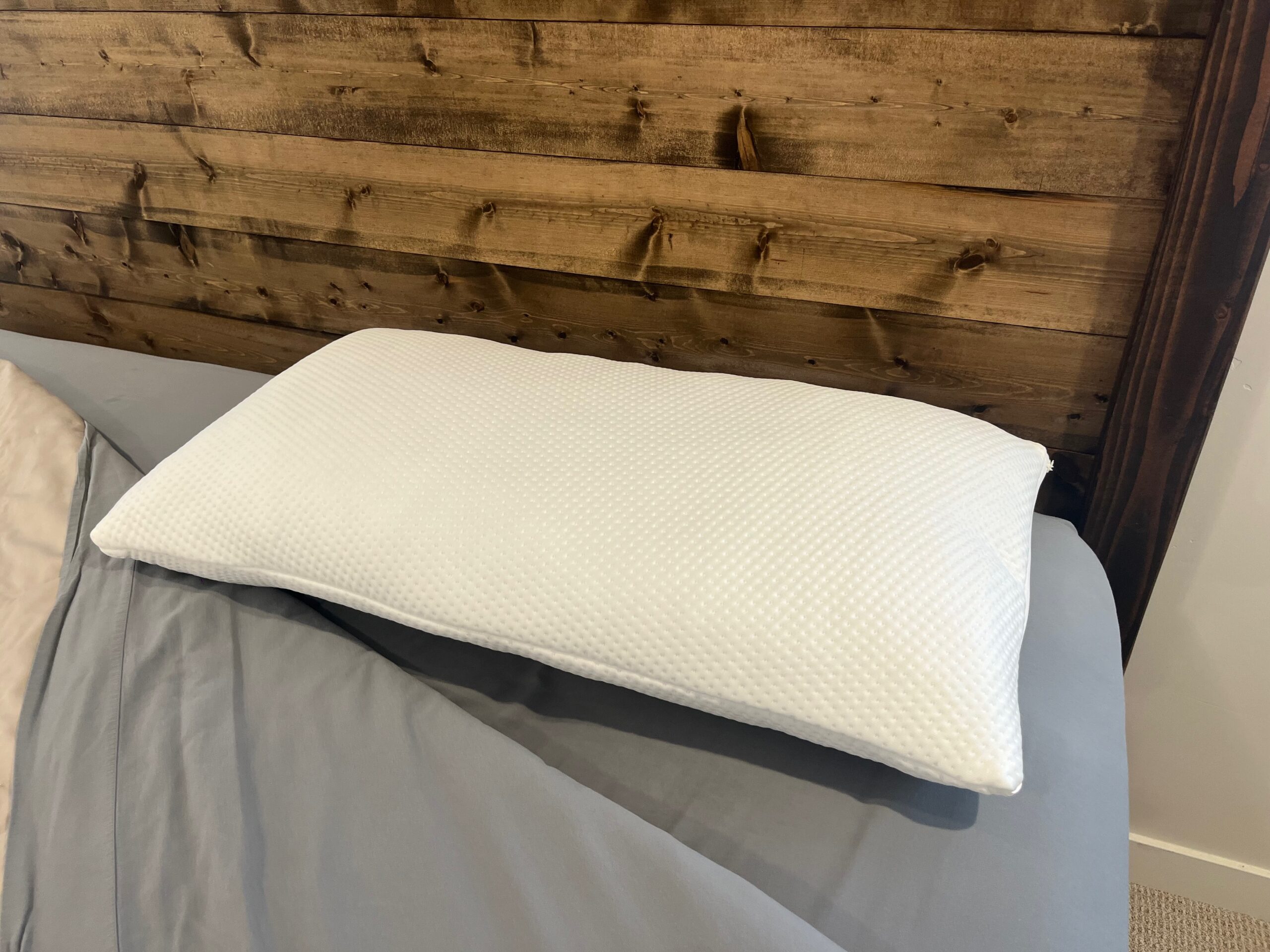 Bear Adjustable Pillow with a Double Ice knit cover, shown on a bed.