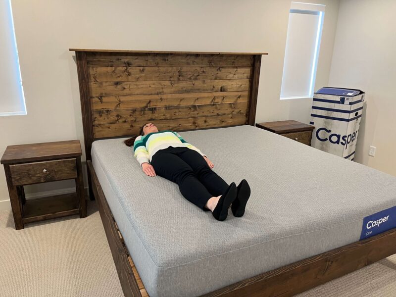 Kristina Hindes lying flat on her back on the Casper One mattress, demonstrating the back sleeping position.