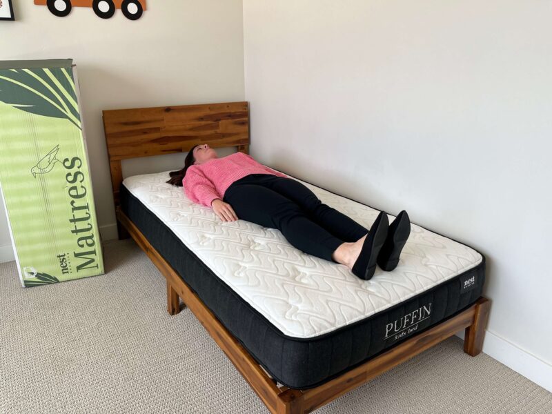 Kristina Hindes lies on her back on the Nest Bedding Puffin Kids mattress.