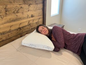 Kristina Hindes performs a side-sleeping test on a Nest Bedding Easy Breather adjustable foam pillow.